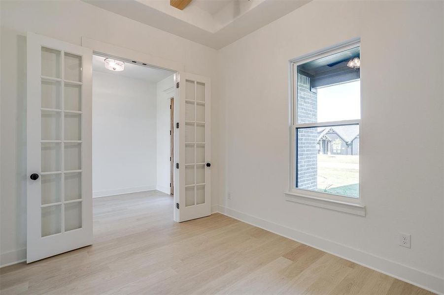 Empty room with french doors and light wood-type flooring