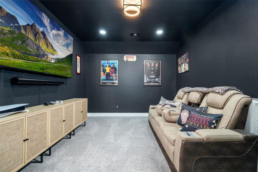 Enjoy movie nights in the cozy media room, complete with plush carpet, recessed lighting for the perfect ambiance, and dark custom paint. Enjoy movie nights in the cozy media room, complete with plush carpet, recessed lighting for the perfect ambiance, and dark custom paint.