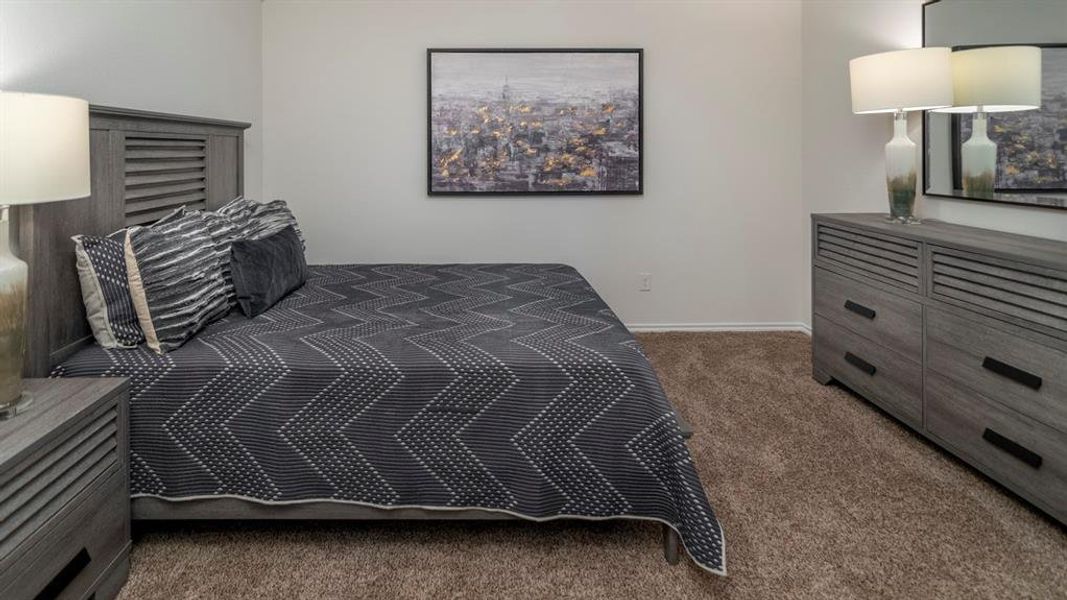 Bedroom with dark carpet and baseboards