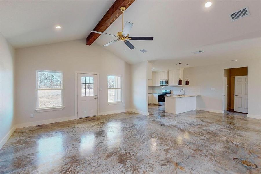 Unfurnished living room with sink, beam ceiling, high vaulted ceiling, and ceiling fan