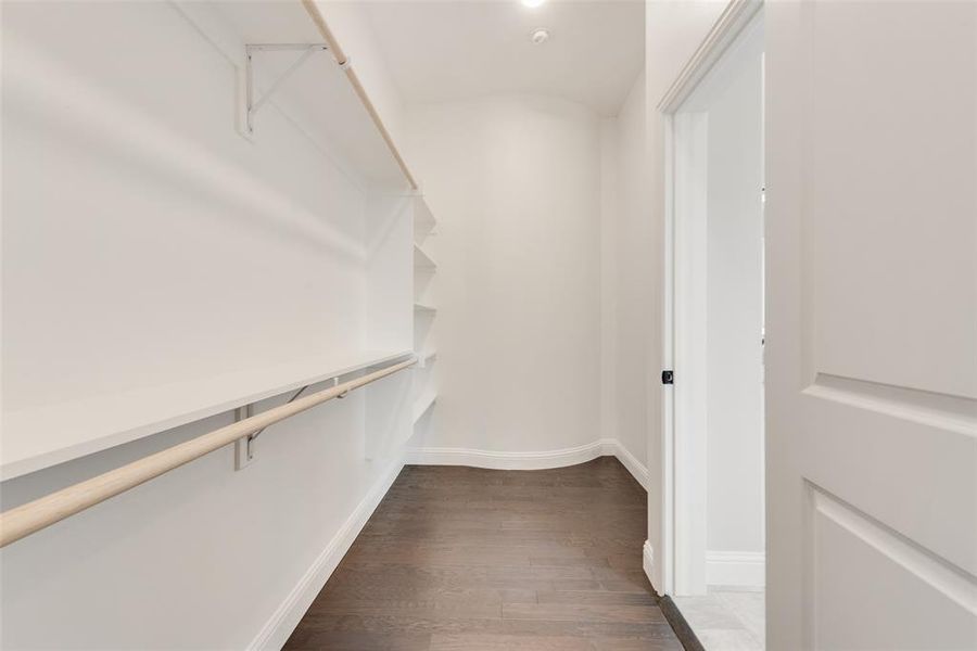 Walk in closet featuring dark wood finished floors Walk in closet featuring dark wood finished floors