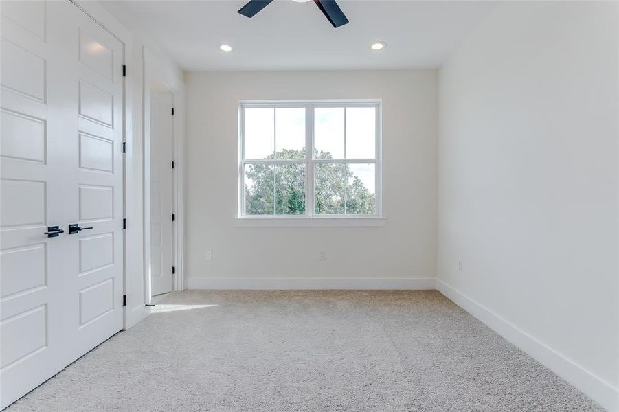 Unfurnished room featuring ceiling fan and light colored carpet