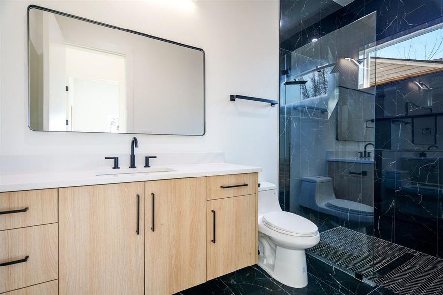 Bathroom with an enclosed shower, vanity, and toilet