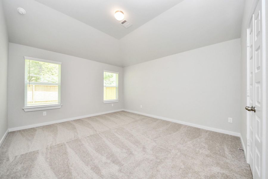 Come and unwind after a long day in this magnificent primary suite! This spacious room features plush carpet, warm paint, high ceilings and large windows with privacy blinds. Sample photo of completed home with similar floor plan. Actual colors and selections may vary.
