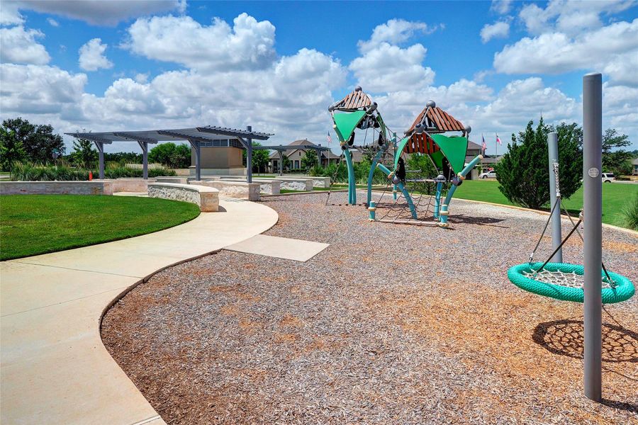 Community play area with a pergola and a lawn Community play area with a pergola and a lawn