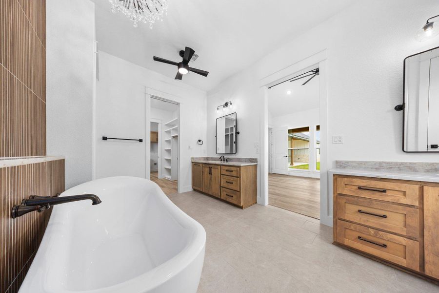 Full bath featuring vanity, ceiling fan, a soaking tub, a spacious closet, and tile patterned flooring Full bath featuring vanity, ceiling fan, a soaking tub, a spacious closet, and tile patterned flooring