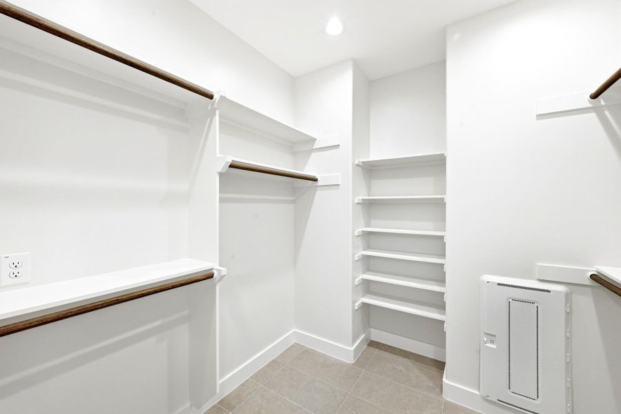 Ample storage solutions define this practical walk-in closet, ready for personalized organization. Ample storage solutions define this practical walk-in closet, ready for personalized organization.