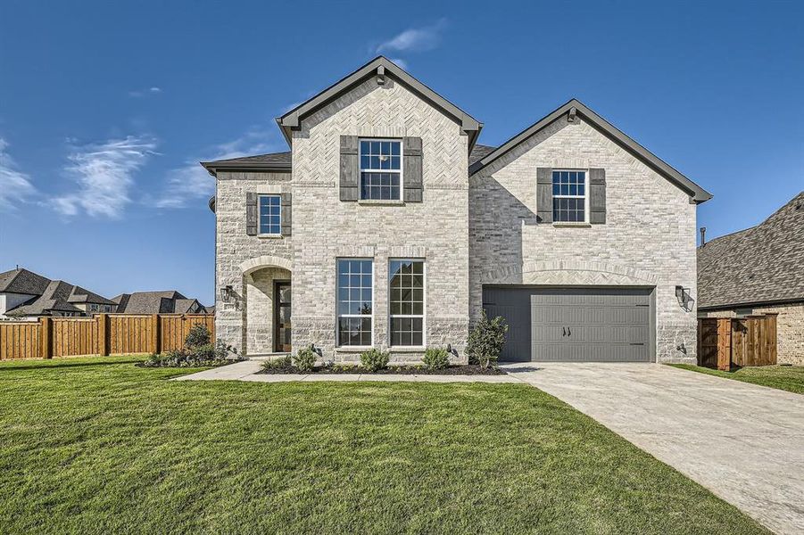 View of front facade featuring a front lawn and a garage