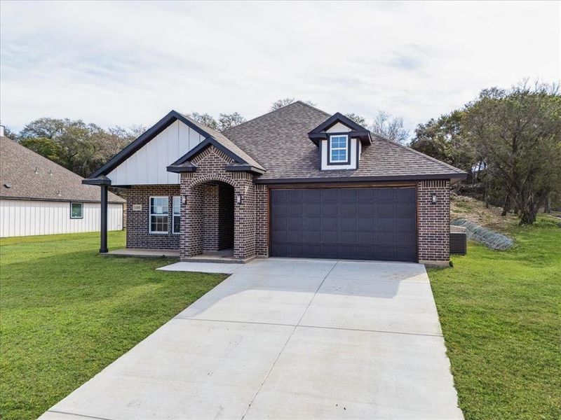 View of front of home featuring a garage and a front lawn