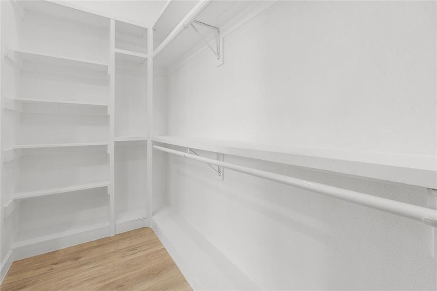 Walk in closet with light wood-style floors Walk in closet with light wood-style floors