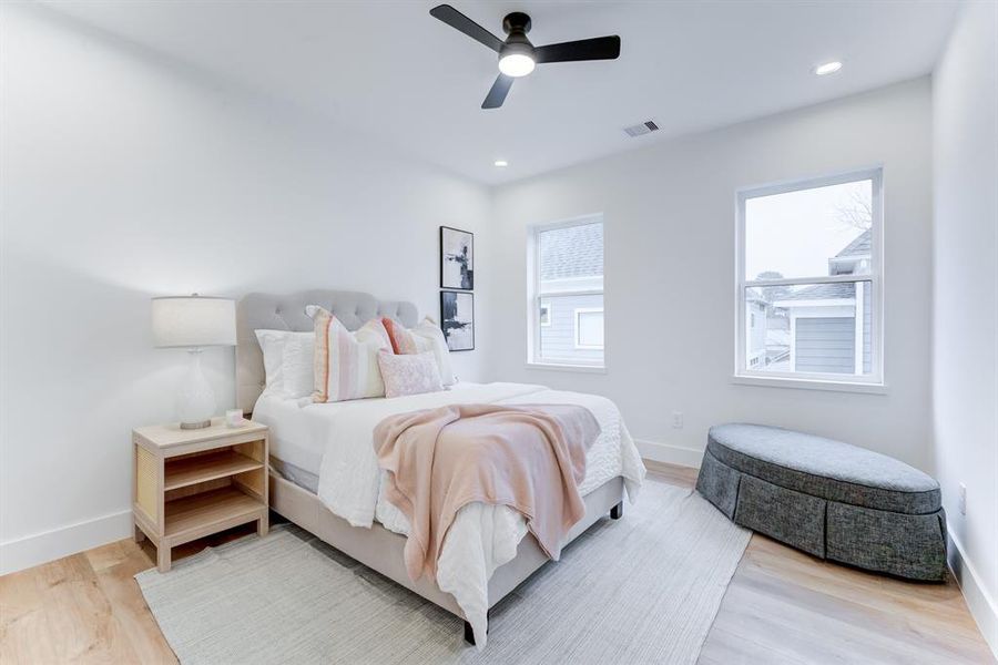 The 2 large windows in the secondary room brings in an abundance of light. There is also a ceiling fan, recessed lighting, and luxury vinyl plank floors.