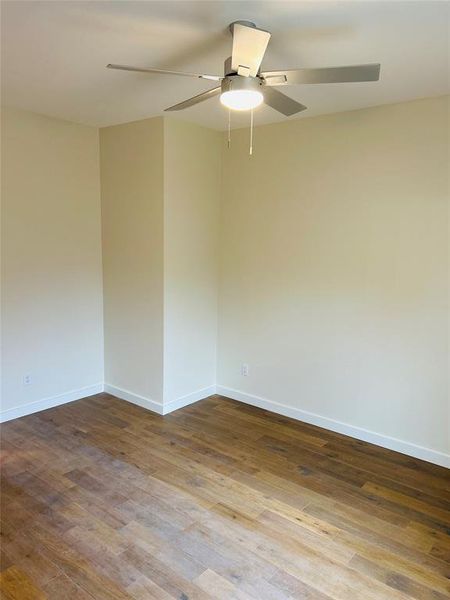 Master bedroom featuring dark wood-type flooring and ceiling fan