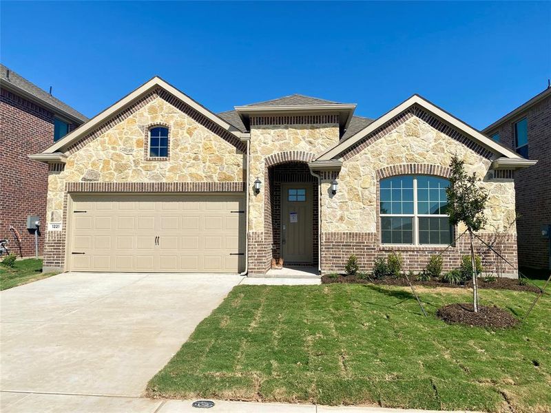 View of front of house featuring a garage and a front lawn