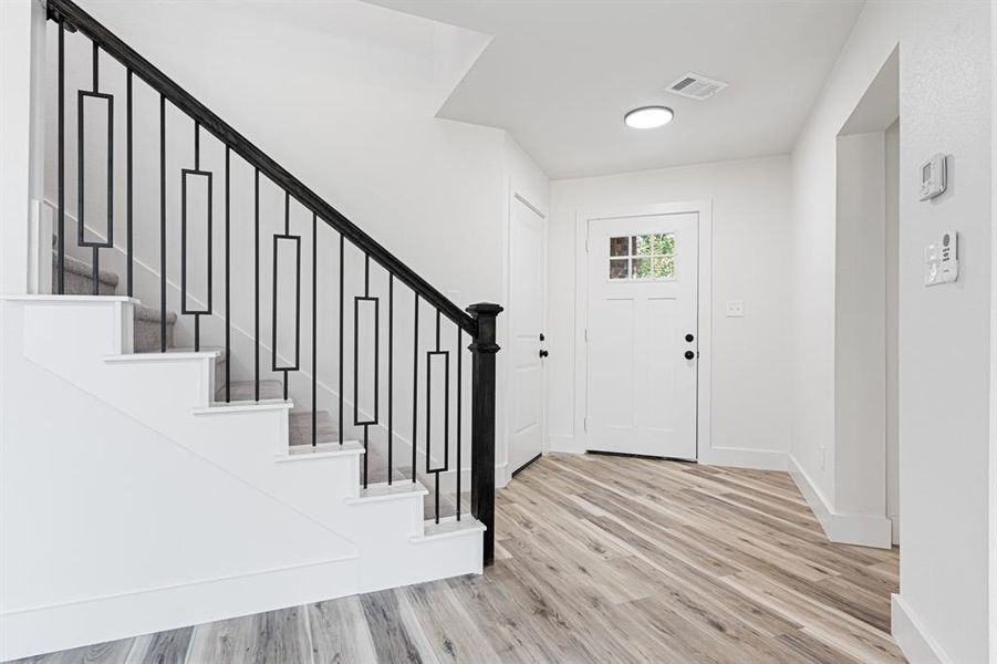 Foyer with light wood finished floors and stairway