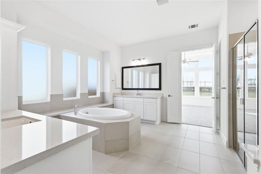 Bathroom featuring vanity, a stall shower, a bath, light tile patterned floors, and ceiling fan Bathroom featuring vanity, a stall shower, a bath, light tile patterned floors, and ceiling fan