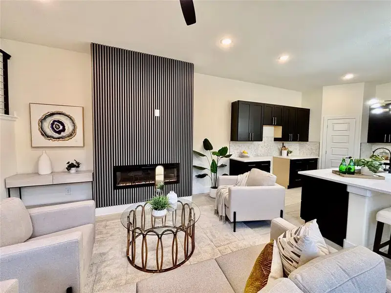 Living area with recessed lighting, a ceiling fan, and a glass covered fireplace