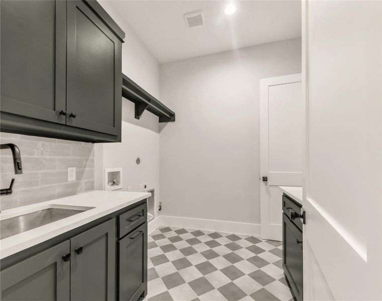 Washroom with cabinet space, light floors, hookup for a washing machine, and hookup for an electric dryer