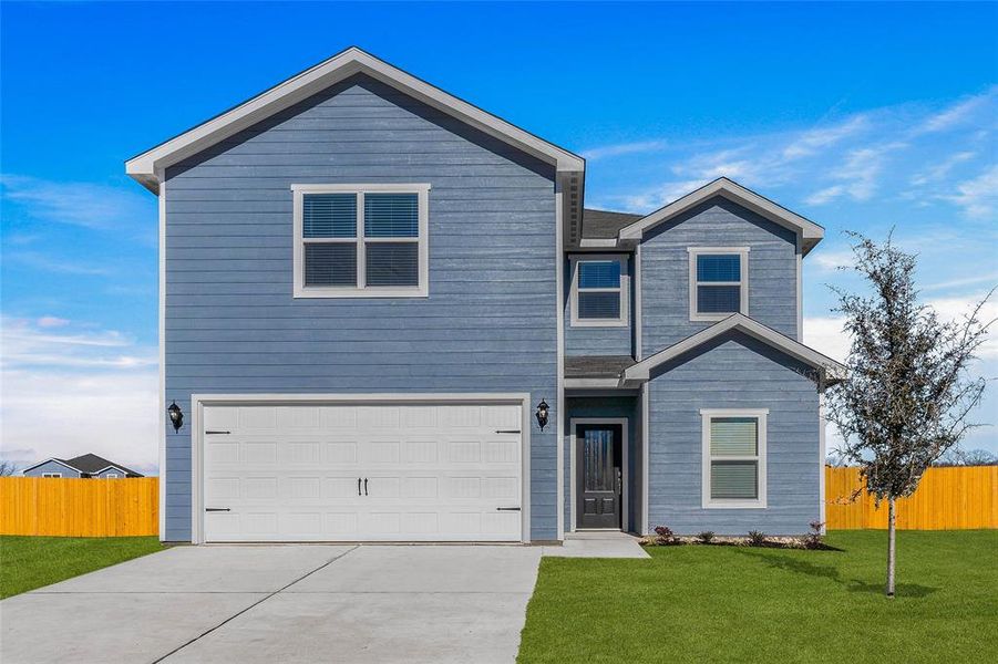 View of front of house featuring a garage and a front lawn