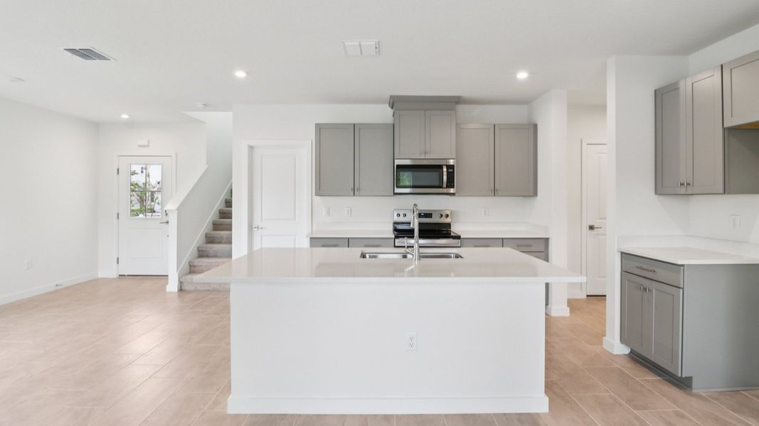 Kitchen and Living Room in the Monterey End Townhome by DRB Homes - Cyrene at Harmony in St Cloud FL