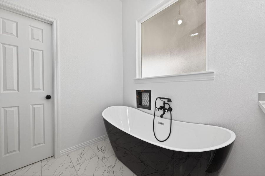 Relaxing soaking tub and separate shower create a spa-like experience.