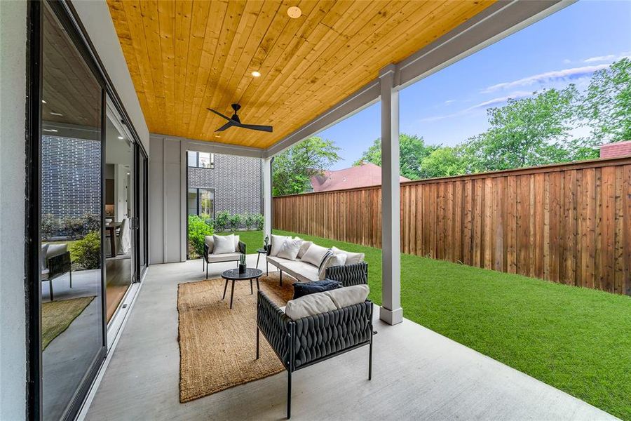Expansive covered patio featuring a wood-panel ceiling with recessed lighting and a ceiling fan