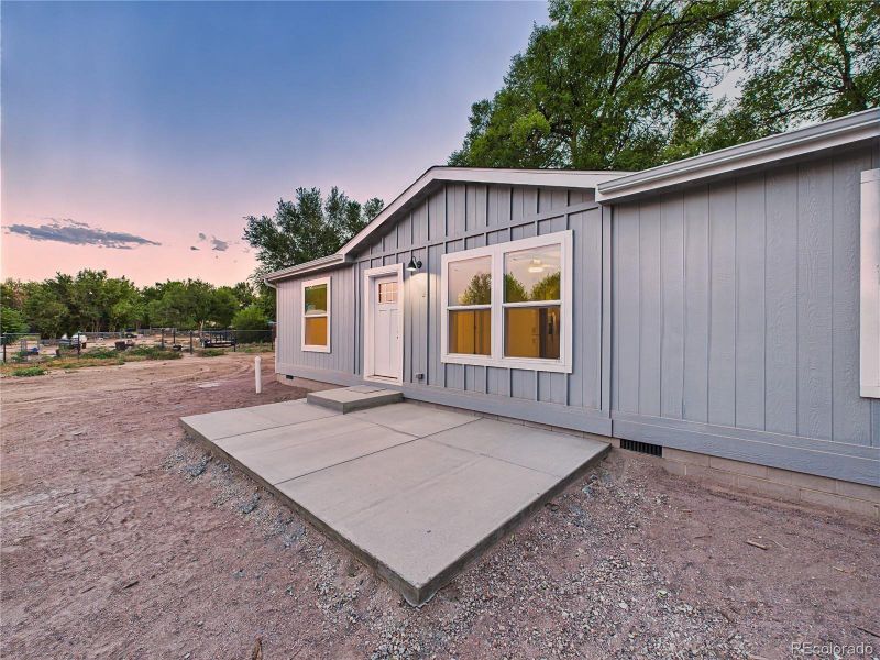 Large front concrete patio provides space for outdoor seating.