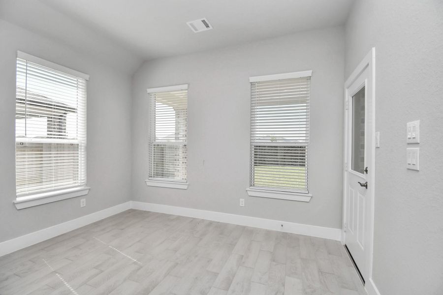 Enjoy breakfast with ease in the connected and cozy breakfast area, seamlessly integrated with the kitchen for utmost convenience. Step through the back door for a breath of fresh air onto the covered patio, extending your living space to the outdoors. Sample photo of completed home with similar floor plan. Actual colors and selections may vary.