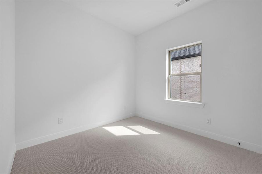 Unfurnished room featuring light carpet and baseboards