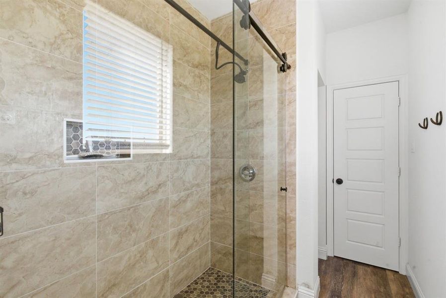 Full bath featuring a stall shower and dark wood-style flooring Full bath featuring a stall shower and dark wood-style flooring