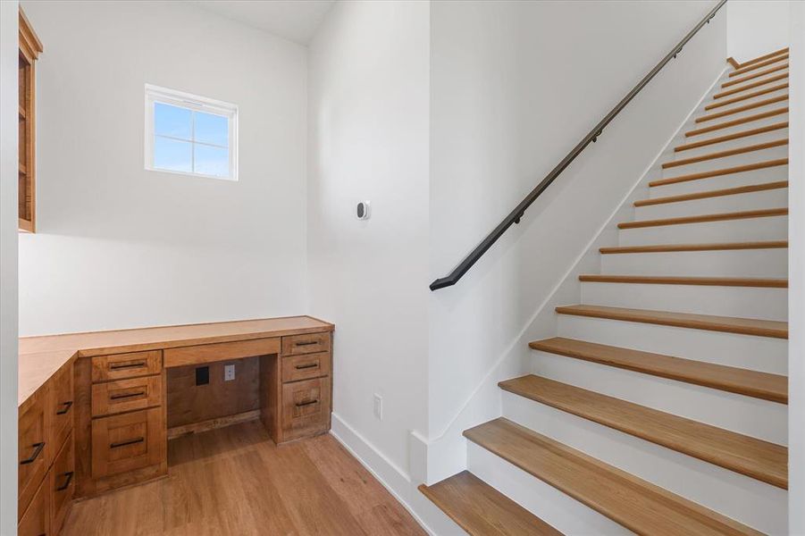 Stairs with built in desk and wood finished floors