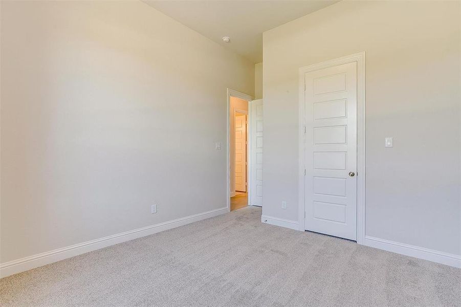 Unfurnished bedroom featuring light carpet and a closet