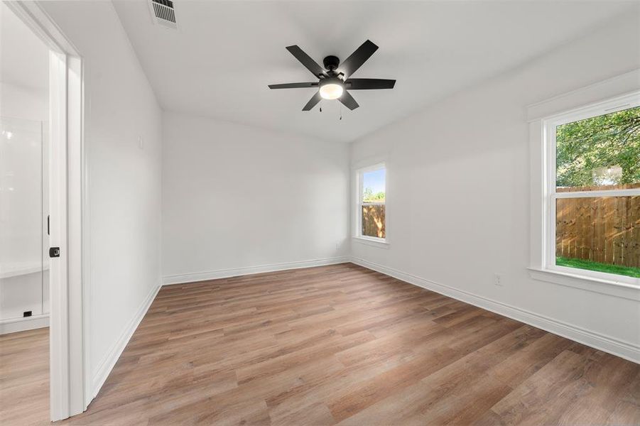 Unfurnished room with light wood finished floors and a ceiling fan Unfurnished room with light wood finished floors and a ceiling fan
