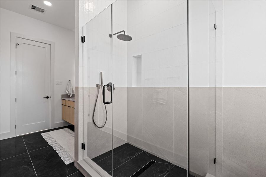 A modern walk-in shower with a frameless glass enclosure, body wand & recessed niche designed for daily function with a refined sensibility. A modern walk-in shower with a frameless glass enclosure, body wand & recessed niche designed for daily function with a refined sensibility.