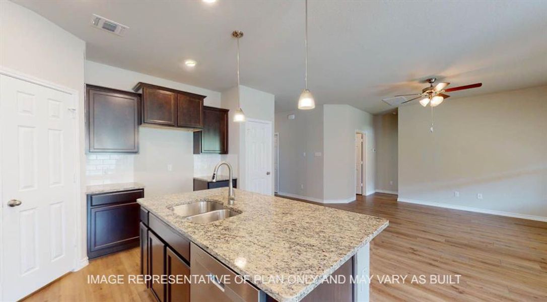 Kitchen featuring a sink, stainless steel dishwasher, ceiling fan, light wood-style floors, and dark brown cabinets Kitchen featuring a sink, stainless steel dishwasher, ceiling fan, light wood-style floors, and dark brown cabinets