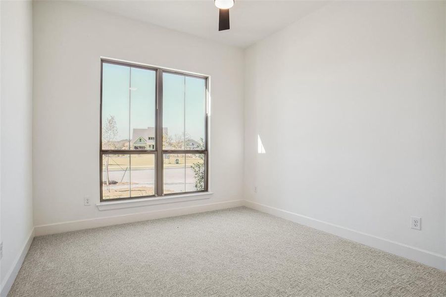 Empty room featuring carpet flooring and ceiling fan