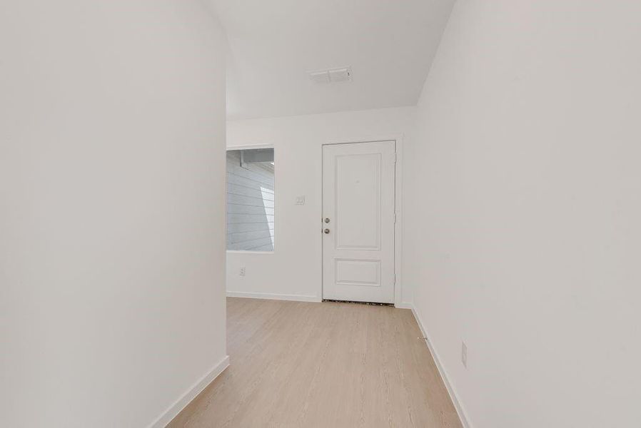 Hallway with baseboards and light wood finished floors