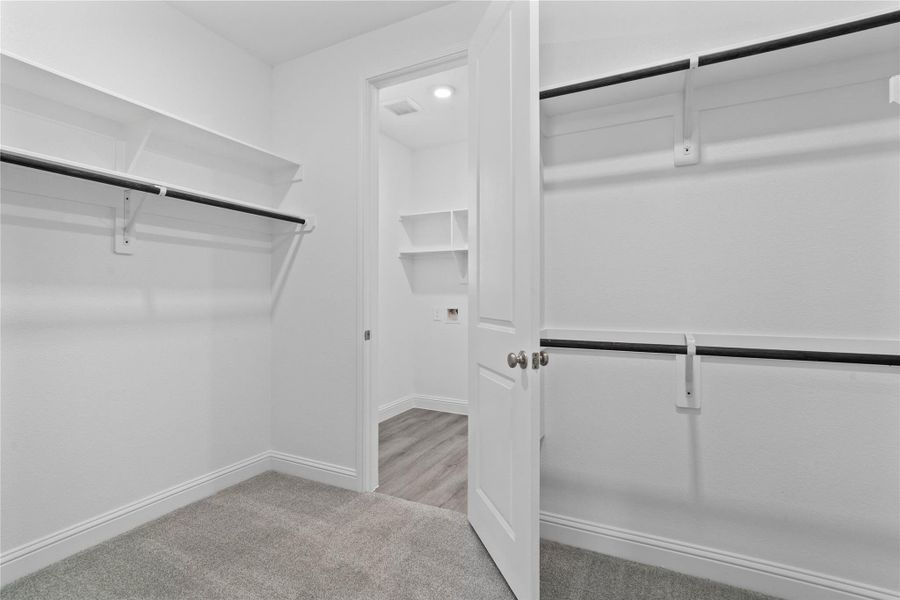 Look at this immaculate closet! With high shelving, multiple rows to hang clothing, you are sure to have enough room for all your belongings! Additional feature is the easy access into the laundry room from primary walk-in closet. Look at this immaculate closet! With high shelving, multiple rows to hang clothing, you are sure to have enough room for all your belongings! Additional feature is the easy access into the laundry room from primary walk-in closet.