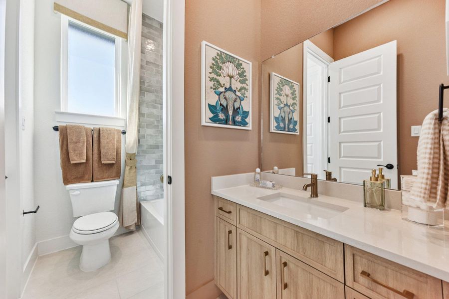 Warm wood tones and clean stone counters define this modern bathroom layout.
