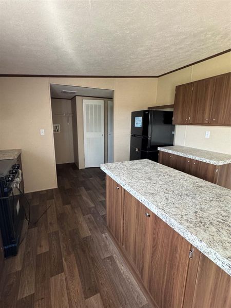 Laminate flooring and a central island ground this functional kitchen workspace.