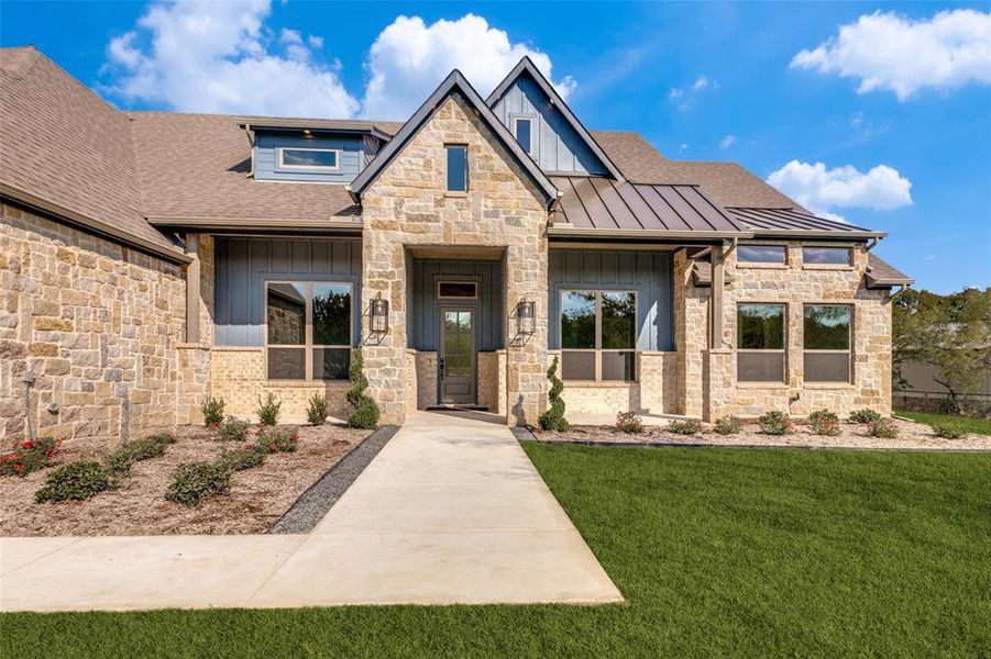 View of front facade featuring board and batten siding, stone siding, a front lawn, and a shingled roof View of front facade featuring board and batten siding, stone siding, a front lawn, and a shingled roof