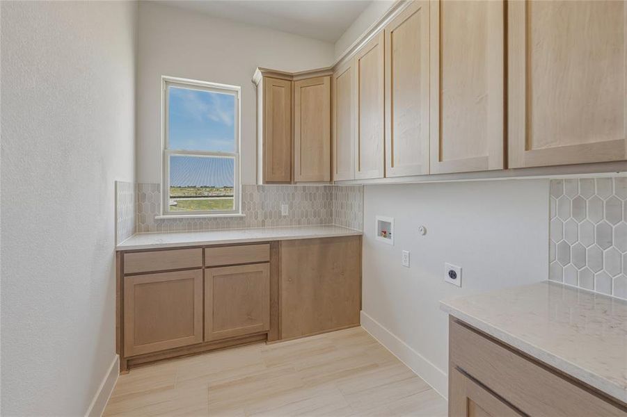 Light wood-finish cabinetry, light-toned countertops, and geometric tile backsplash Light wood-finish cabinetry, light-toned countertops, and geometric tile backsplash
