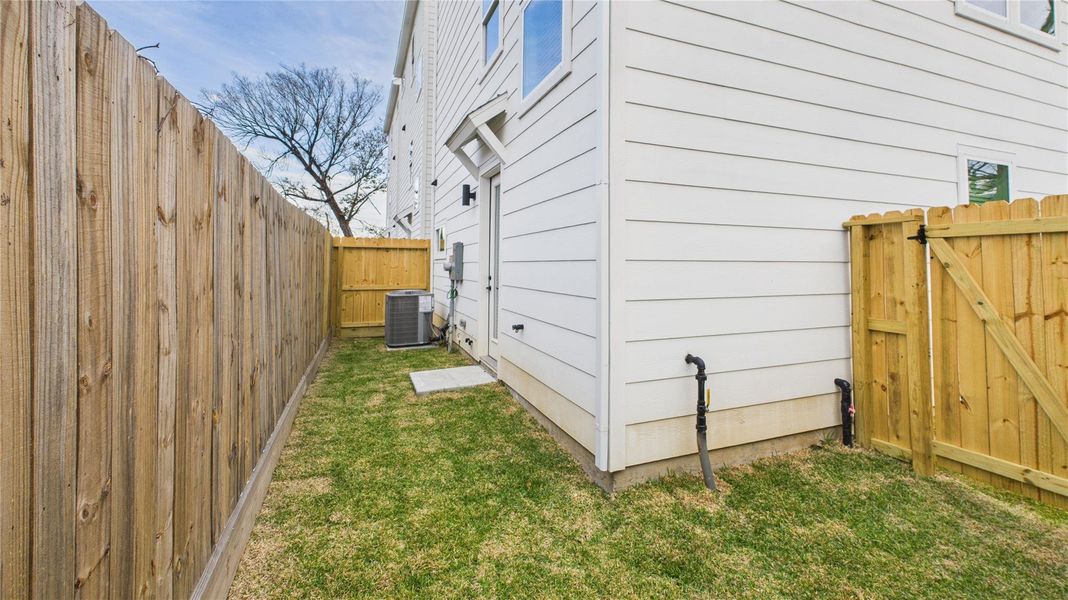 This cozy backyard patio offers a charming outdoor retreat, accessible directly from the secondary bedroom and through a wooden gate that leads to the driveway, providing convenient indoor-outdoor flow and added privacy.