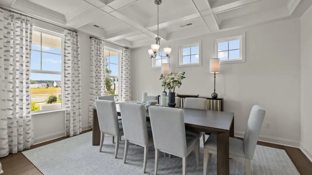 Bright and luxurious dining room with raised coffered ceiling and plentiful windows, in the Townsend Design by DRB Homes Bright and luxurious dining room with raised coffered ceiling and plentiful windows, in the Townsend Design by DRB Homes