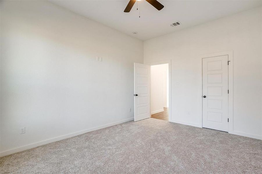 Spare room featuring light carpet and ceiling fan