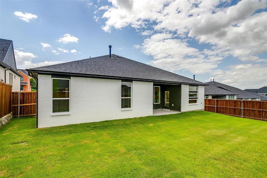 Back of property with a patio and a lawn