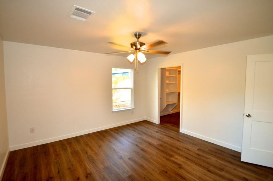 Unfurnished room with dark wood-style floors and ceiling fan
