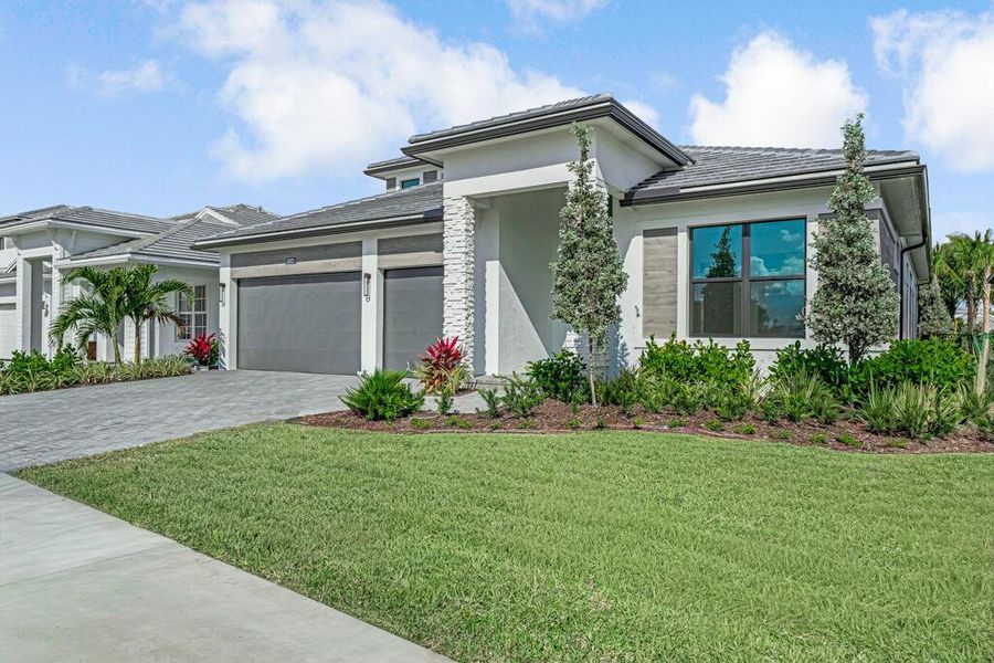 Front exterior of a new home in Esprit at Avenir, Palm Beach Gardens, FL, highlighting curb appeal (Image 22). Front exterior of a new home in Esprit at Avenir, Palm Beach Gardens, FL, highlighting curb appeal (Image 22).