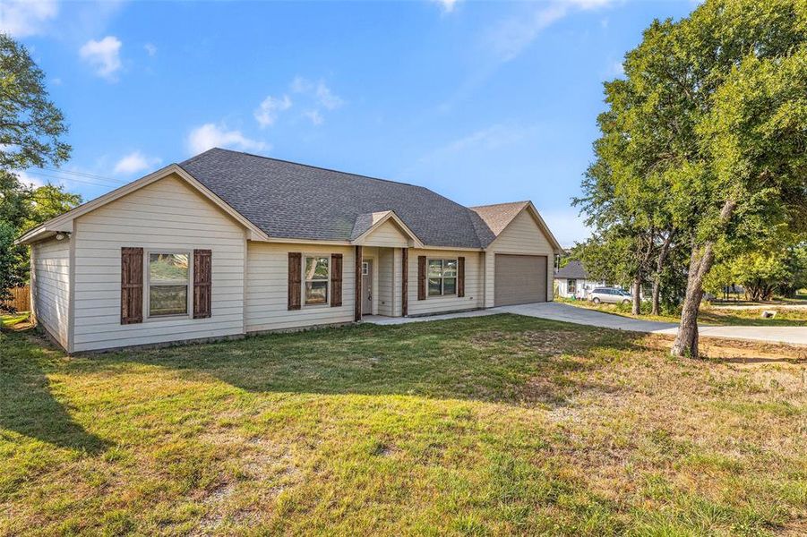 Single story home with a garage and a front yard