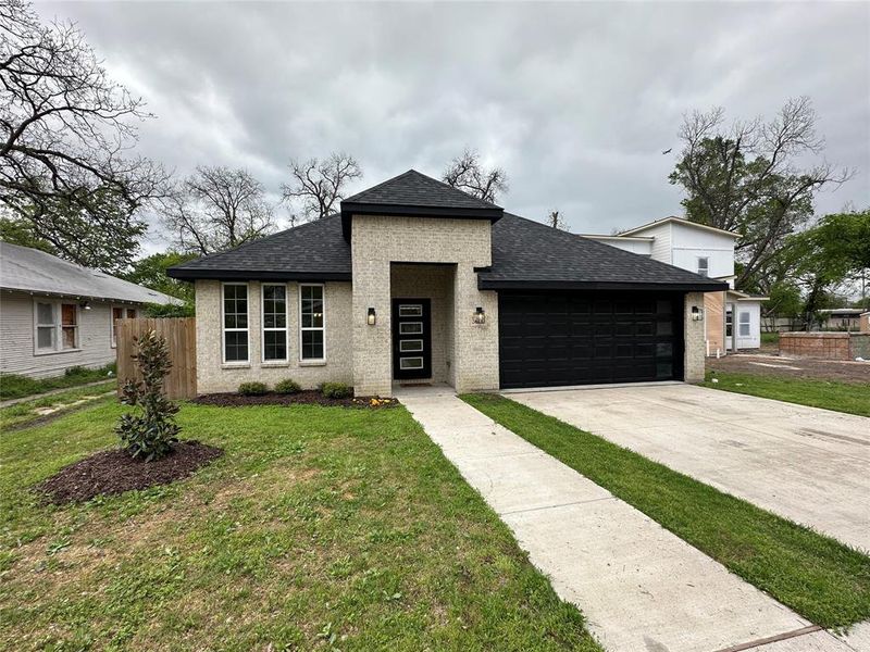 View of front of house with a front yard, a shingled roof, a garage, concrete driveway, and brick siding View of front of house with a front yard, a shingled roof, a garage, concrete driveway, and brick siding