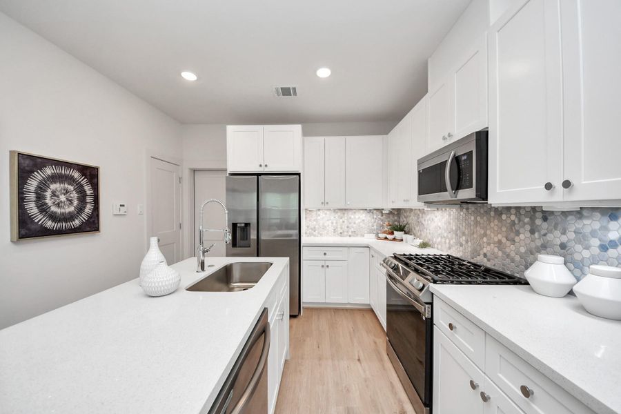 Modern white kitchen featuring minimalist cabinetry. Modern white kitchen featuring minimalist cabinetry.